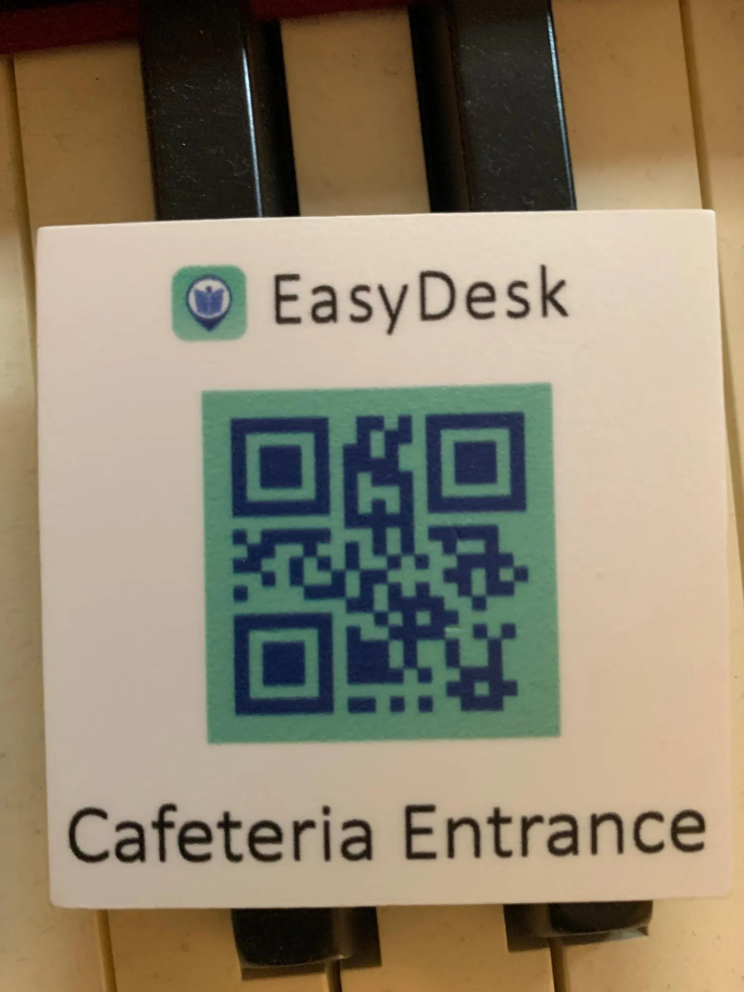 An EasyDesk tag reading 'Cafeteria Entrance', with the app logo and a QR code