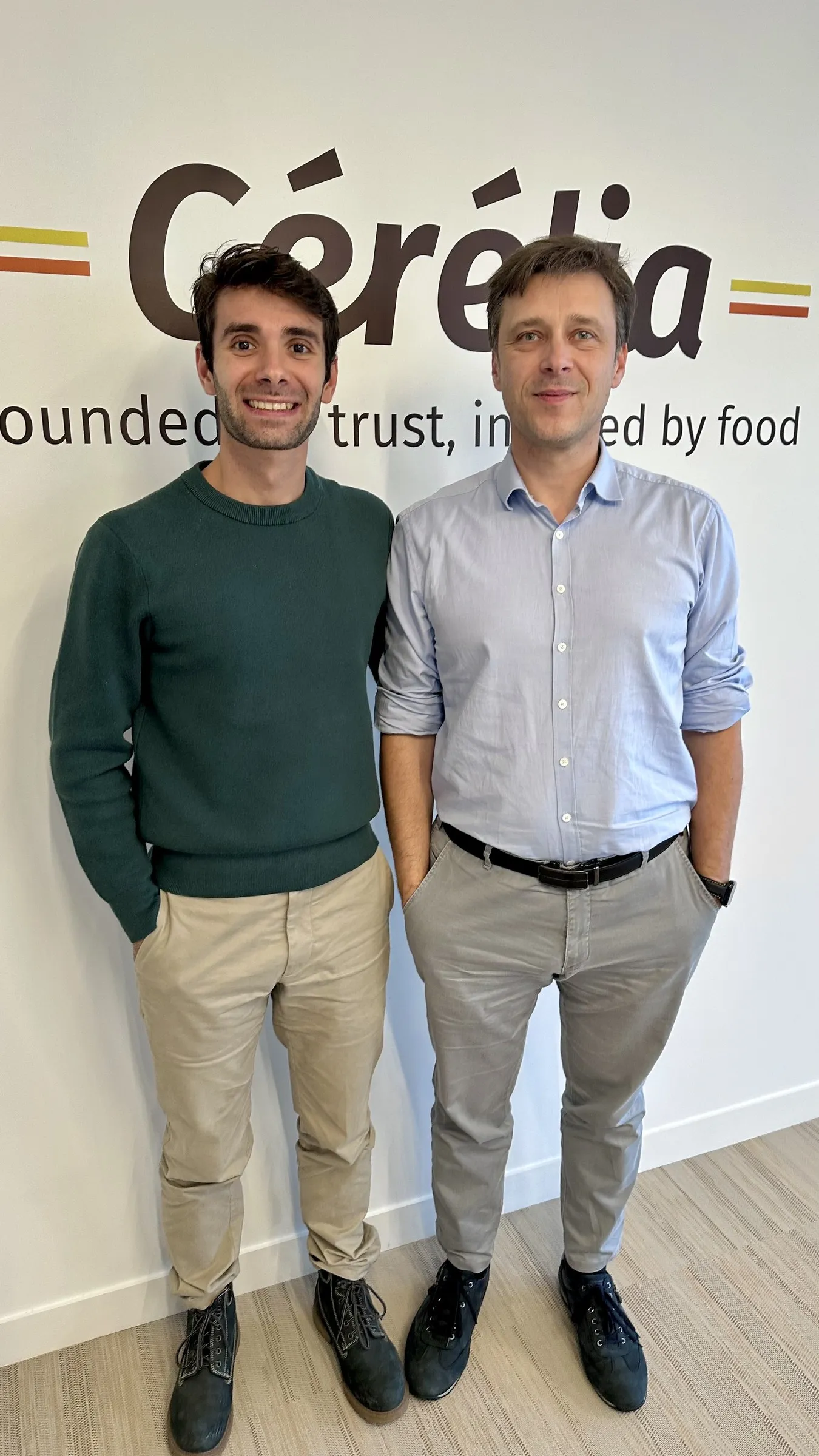 Enrico con un collega di Cérélia davanti al logo dell’azienda, ufficio di Parigi