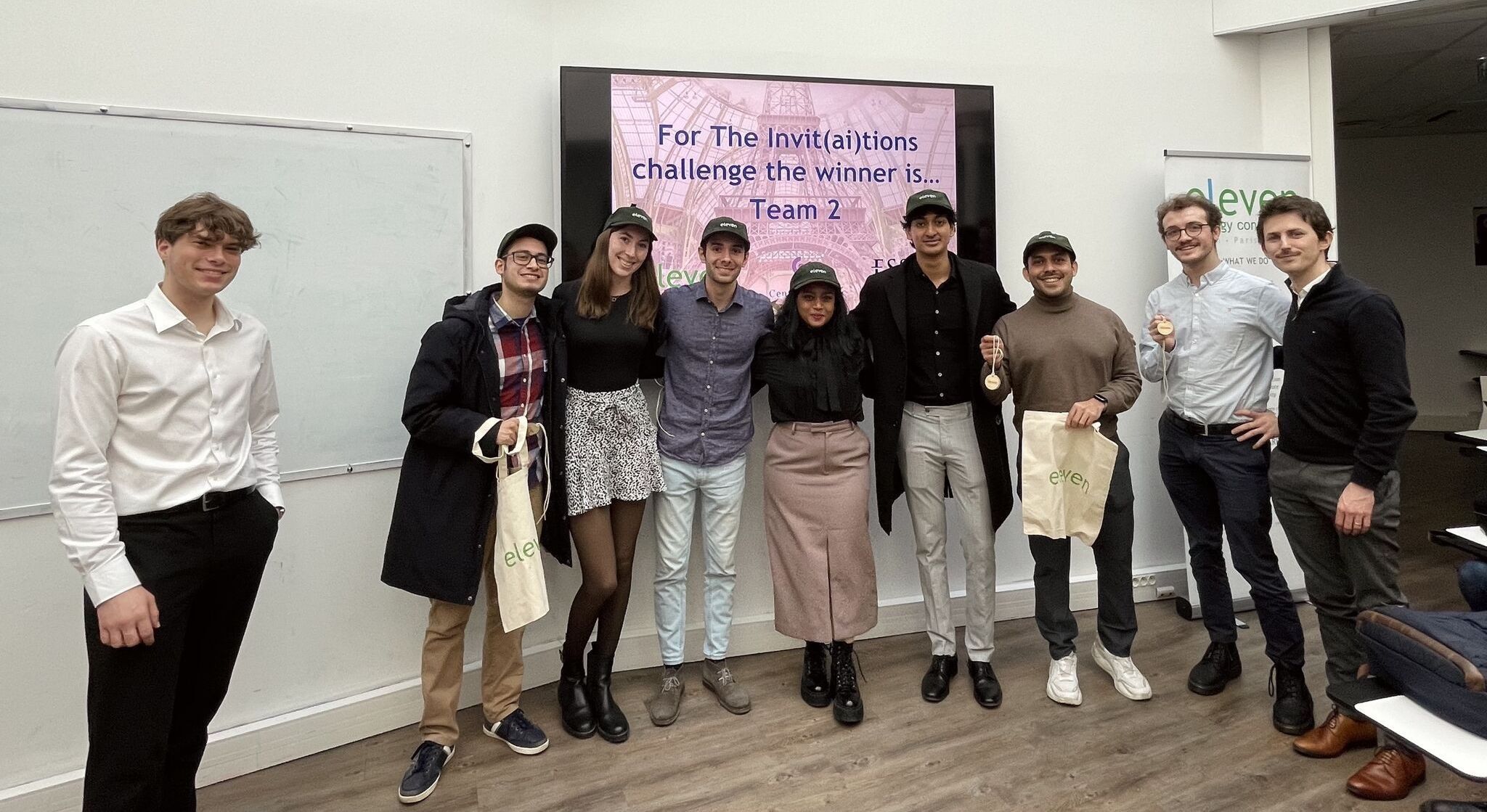 The winning team in front of the screen announcing 'The InvitAItion' as the challenge winner
